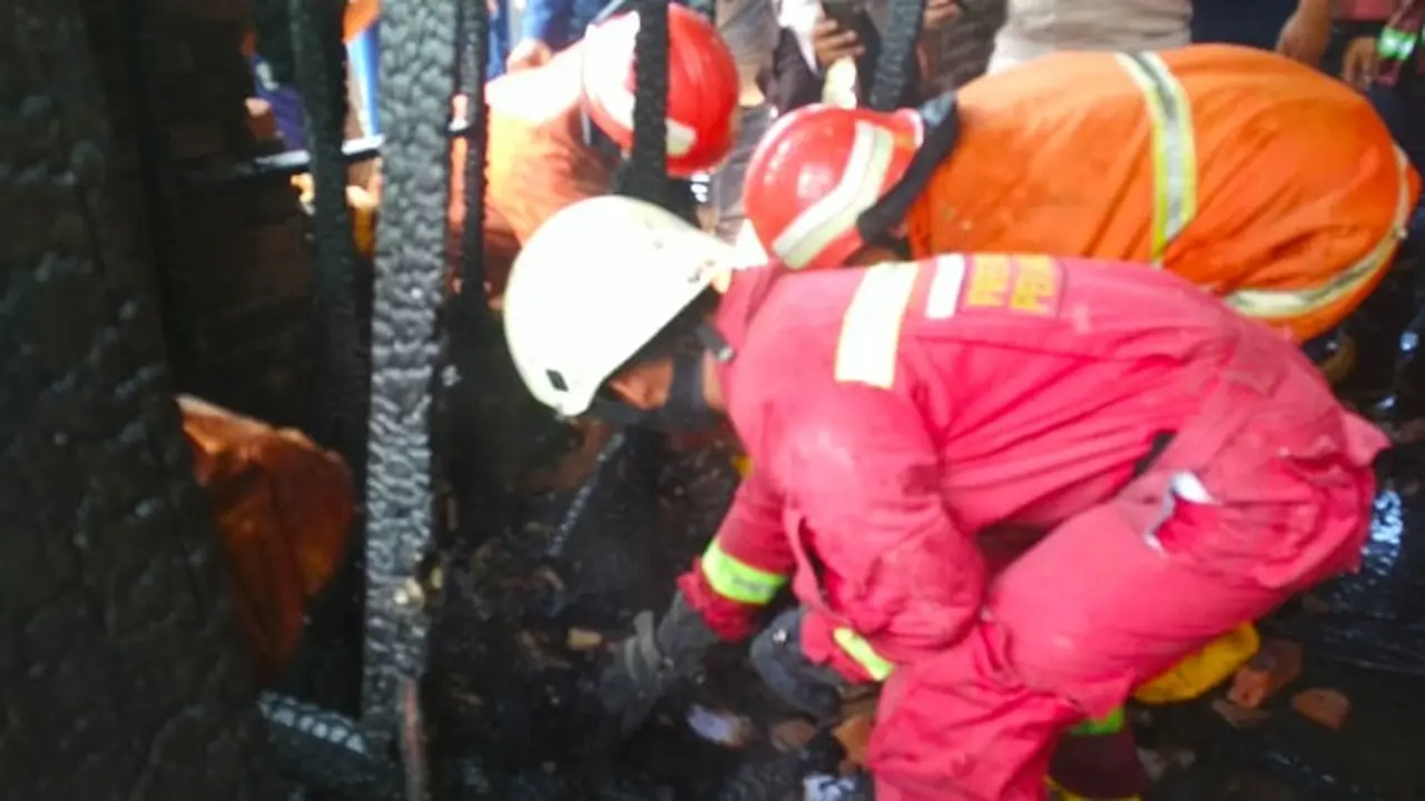 Petugas mengevakuasi jenazah bocah tewas terbakar dari lemari tempatnya bersembunyi.