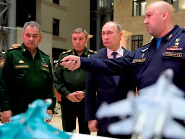 Presiden Rusia Vladimir Putin (kedua kanan) mendengarkan Komandan Angkatan Udara Rusia Sergei Surovkin (kanan) saat mengunjungi sebuah pameran di markas militer Rusia di Moskow (30/1). (Mikhail Klimentyev, Sputnik, Kremlin Pool/AP)