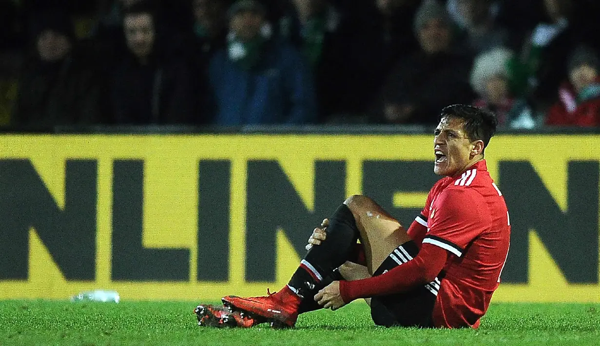 Penyerang MU, Alexis Sanchez terlihat kesakitan saat dilanggar pemain Yeovil Town pada putaran keempat Piala FA di Huish Park di Yeovil, Somerset (26/1). Sanchez langsung menjadi man of the match pada laga debutnya. (AFP Photo)