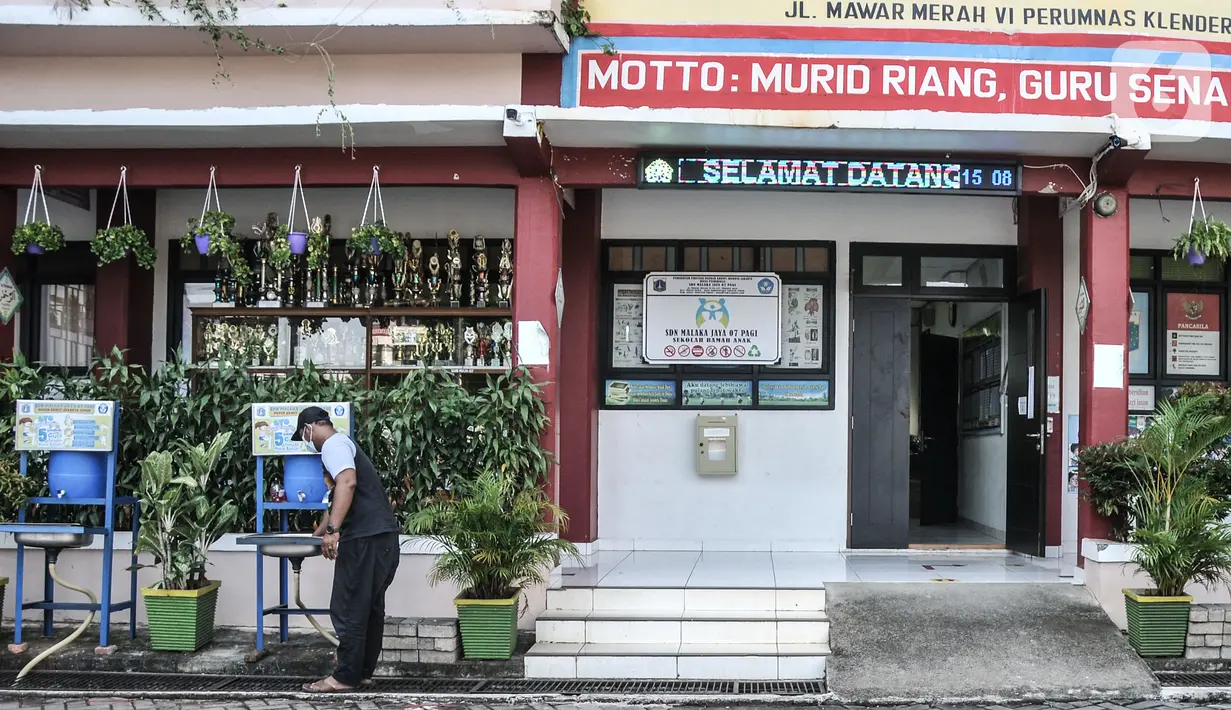Petugas menyiapkan fasilitas pencuci tangan di Sekolah Dasar Negeri (SDN) Malaka Jaya 07 Pagi, Jakarta, Kamis (26/8/2021). Pemprov DKI berencana membuka kembali sekolah untuk pembelajaran tatap muka terbatas pada Senin (30/8) setelah status PPKM turun ke level 3. (merdeka.com/Iqbal S Nugroho)