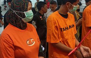 Pasutri berinisial SK (24) dan SM (39) saat mengenakan baju tahanan. (Liputan6.com/ Fauzan)