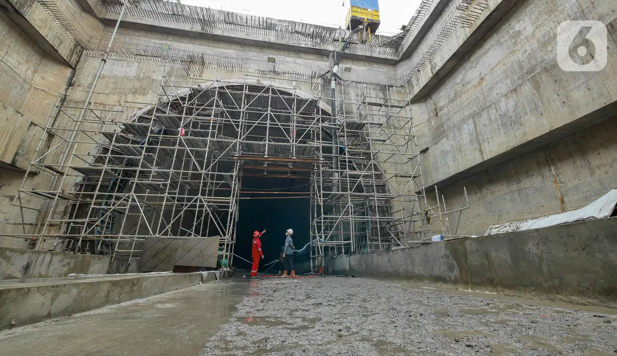 Pekerja menyelesaikan pengerjaan proyek Tunnel 1 Halim Kereta Cepat Jakarta-Bandung di Jalan Tol Jakarta-Cikampek KM 5+500, Jakarta, Kamis (27/1/2022). Tunnel 1memiliki panjang 1.885 meter dan dibangun dengan metode Tunnel Boring Machine (TBM). 
(Liputan6.com/Herman Zakharia)