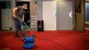 Pekerja menggunakan penyedot debu saat bersiap menyambut pembukaan kembali bioskop Le Grand Rex di Paris, Prancis (22/6/2020). Bioskop dan kasino kini kembali melanjutkan operasi dan kegiatan olahraga yang menarik tidak lebih dari 5.000 orang akan kembali diizinkan. (Xinhua/Aurelien Morissard)