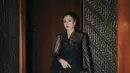 Wulan Guritno memilih busana bernuansa gelap yang memancarkan aura anggun dan elegan. Ia mengenakan kebaya hitam transparan dengan motif tradisional yang dipercantik bordir emas, sebuah karya dari Tangan Prive.