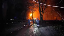 Serangan udara ini menargetkan infrastruktur energi serta menghancurkan sejumlah gedung apartemen warga sipil. Tampak dalam foto, orang-orang berdiri di luar gedung yang terbakar setelah serangan Rusia di Kryvyi Rih, Ukraina, Kamis, 8 Januari 2026. (AP Photo/Mykola Myrnyi)