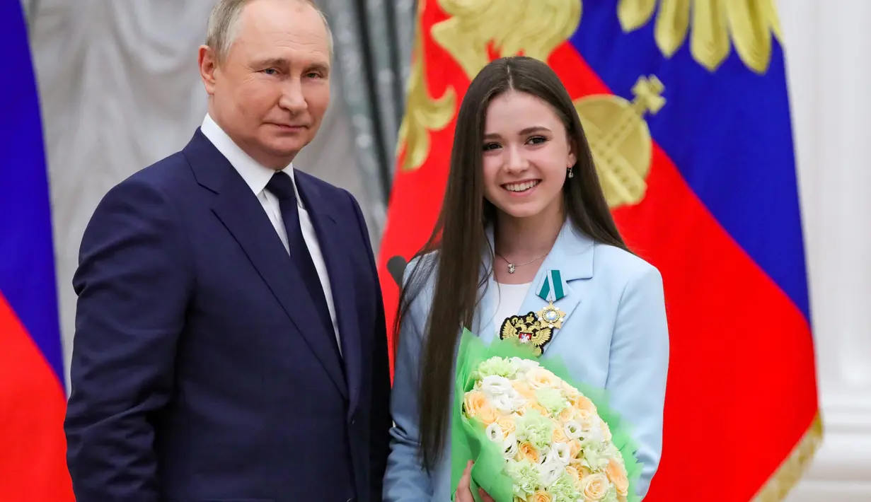 <p>Presiden Rusia Vladimir Putin berpose dengan figure skater Kamila Valieva selama upacara penghargaan untuk pemenang medali Olimpiade Musim Dingin Beijing 2022 di Kremlin di Moskow (26/4/2022). (Mikhail KLIMENTYEV/SPUTNIK/AFP)</p>