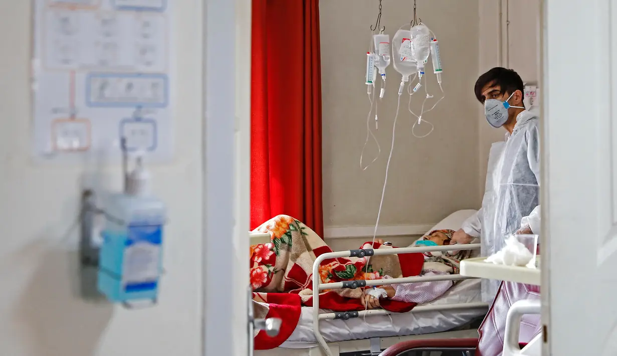 Petugas medis merawat seorang pasien yang terinfeksi virus corona atau COVID-19 di sebuah rumah sakit di Teheran, Iran, Minggu (1/3/2020). Sejauh ini, Iran mencatat ada 1.501 kasus virus corona dengan 66 korban meninggal. (Ali Shirband/Mizan News Agency via AP)