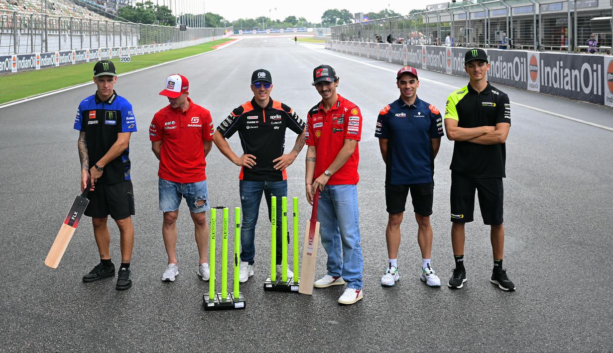 Sejumlah pembalap MotoGP termasuk Francesco Bagnaia (tengah kanan) berfoto bersama setelah bermain kriket di dalam lintasan menjelang MotoGP India 2023 di Sirkuit Buddh, New Delhi, India pada 21 September 2023. (AFP/Money Sharma)