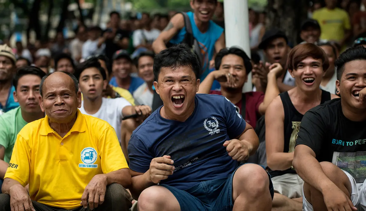 Warga Filipina bereaksi saat menyaksikan petinju idola mereka, Manny Pacquiao, melawan petinju Australia Jeff Horn, pada perebutan gelar kelas welter WBO, di Manila, Minggu (2/7). Ditekuk Horn, Pacquiao kehilangan gelar juara dunia WBO. (Noel CELIS/AFP)