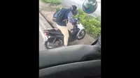 Pengguna motor matic yang terobos jalur busway kesulitan putar balik karena motornya tersangkut median jalan. (Sumber: TikTok/@novanabishaka)