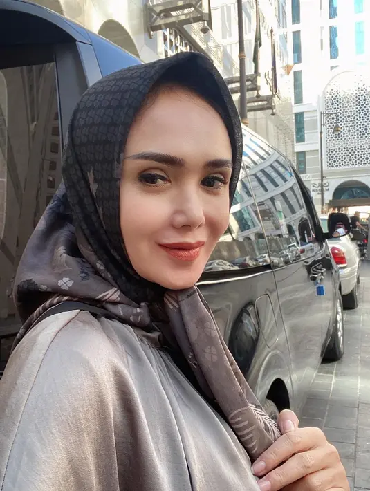 Yuni Shara selfie dengan latar belakang gedung dan mobil mewah. (Foto: Instagram/ yunishara36)