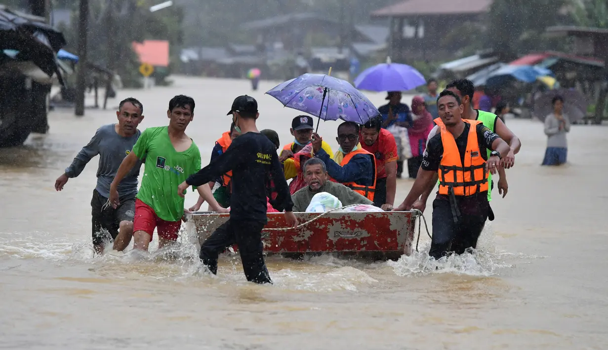 Warga diangkut melalui banjir di distrik Ran-ngea di provinsi Narathiwat, Thailand selatan (26/2/2022).  Lebih dari 7.200 rumah tangga di 195 desa telah terkena dampak, dengan 6.891 rumah rusak, karena Sungai Sungai Kolok yang diguyur hujan terus meluap. (AFP/Madaree Tohlala)