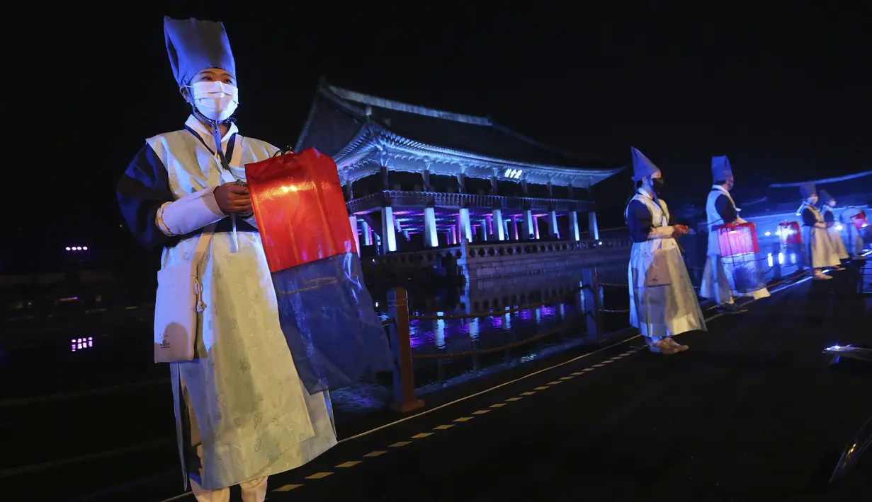 Penampil yang mengenakan masker memegang lentera selama Festival Budaya Kerajaan di Istana Gyeongbok, Seoul, Korea Selatan, Rabu (14/10/2020). Festival warisan budaya selama sebulan yang mengeksplorasi istana dan budaya kerajaan Korea Selatan dimulai pada 10 Oktober 2020. (AP Photo/Ahn Young-joon)