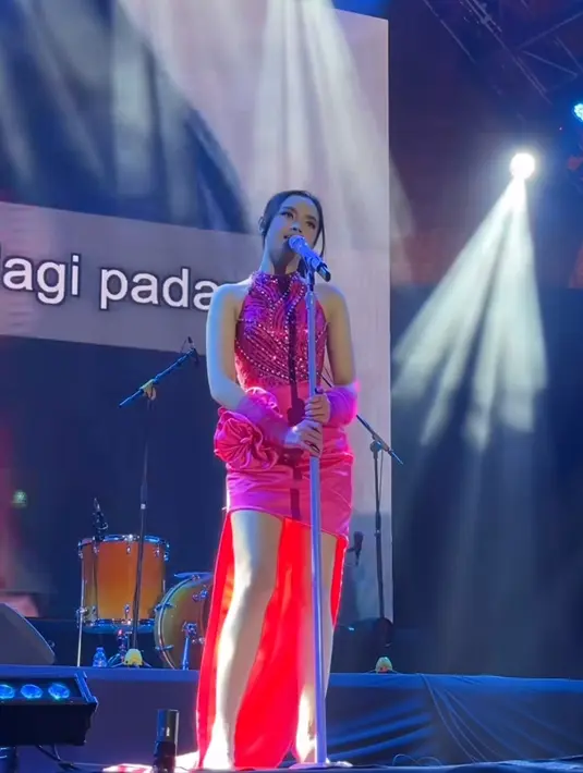 Lyodra mengisi acara tahun baru di Bandung, ia mengenakan mini dress fuschia dengan bagian atasan halter neck dihiasi beads, serta skirt dihiasi bunga besar dan teil. [@summereconmall.bandung]