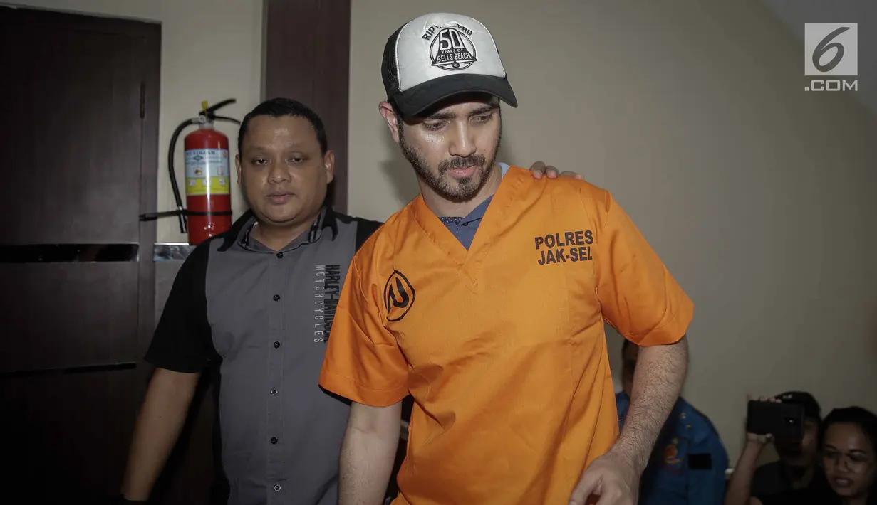 Aktor Fachri Albar dikawal petugas saat dihadirkan dalam gelar rilis di Polres Jakarta Selatan, Rabu (14/2). Selain itu ditemukan juga puntung ganja bekas pakai. (Liputan6.com/Faizal Fanani)