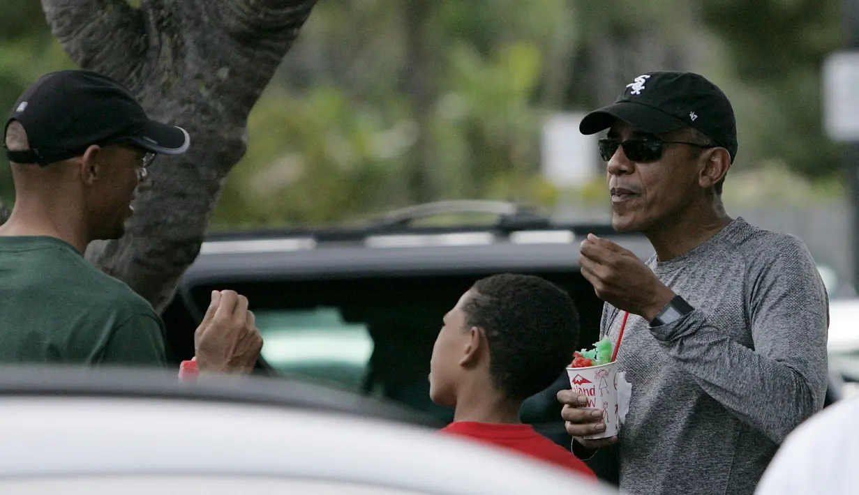Presiden AS Barack Obama berbincang dengan kerabat dan keluarganya sambil menikmati es yang dibelinya disebuah toko minuman dengan keluarga dan teman-teman selama liburan Natal di Kailua, Hawaii, (27/12/2015). (REUTERS/Hugh Gentry)