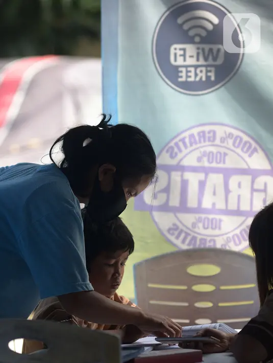 Seorang siswa belajar online di Tenda Wifi gratis di taman warga RT 013, Jakarta Timur, Rabu (12/8/2020). Tenda belajar tersebut menyediakan fasilitas wifi gratis bagi anak-anak sekolah yang terkendala dengan mahalnya kuota internet. (merdeka.com/Imam Buhori)