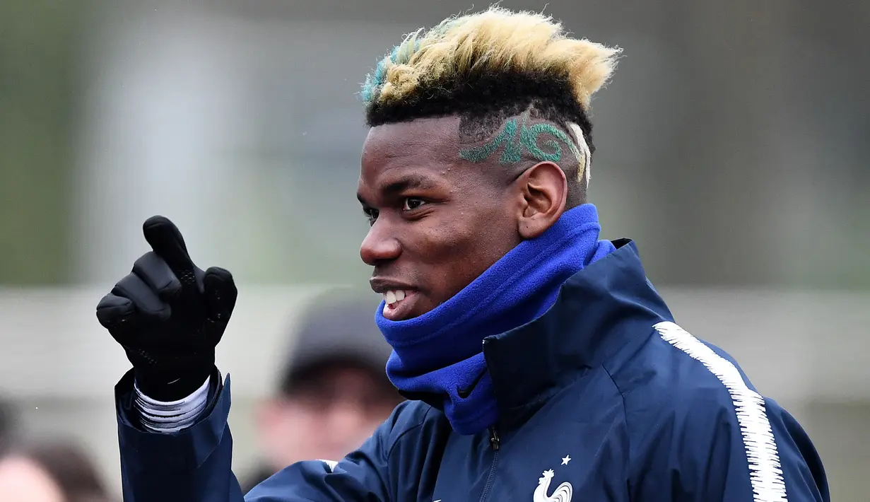 Gelandang timnas Prancis Paul Pogba menyapa penggemar sebelum mengikuti sesi latihan di Clairefontaine-en-Yvelines, Paris (19/3). (AFP Photo/Franck Fife)
