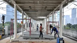 Pekerja menyelesaikan pemasangan atap peron Stasiun Matraman, Jakarta Timur, Kamis (23/12/2021). Pembangunan Stasiun Matraman memasuki pemasangan atap peron, sementara fasilitas pendukung seperti eskalator, sarana umum, dan rambu sudah siap digunakan. (merdeka.com/Iqbal S. Nugroho)