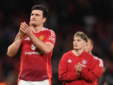 Pemain Manchester United, Harry Maguire merayakan kemenangan atas Lyon dalam laga leg 2 perempat final Liga Europa 2024/2025 di Old Trafford, Manchester, Inggris, Jumat (18/04/2025) WIB. (AFP/Oli Scarff)