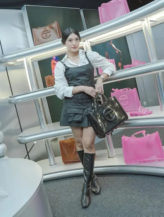 Anissa Aziza juga tampil menawan saat berpose di instalasi ini. Ia mengenakan atasan kemeja putih polos, ditumpuknya dengan leather dress dan memadukannya dengan high leather boots yang juga berwarna hitam. Ia sempurnakan gayanya dengan menenteng totebag berwarna hitam dari koleksi kolaborasi Melissa dan Telfar. [Foto: Instagram/anissaaziza]