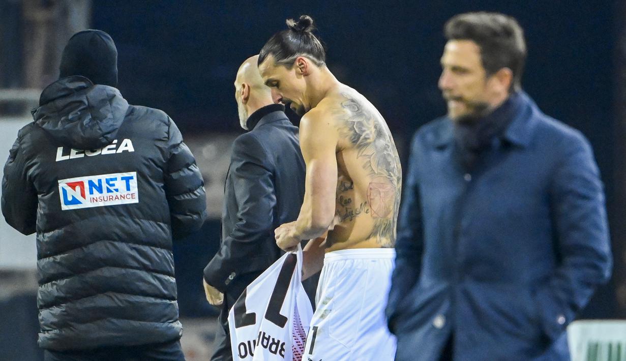 Striker AC Milan, Zlatan Ibrahimovic, menukar jersey saat melawan Cagliari pada laga Liga Italia di Sardegna Arena, Senin (19/1/2021). AC Milan menang dengan skor 2-0. (AFP/Alberto Pizzoli)