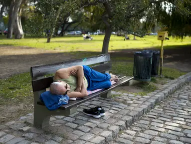 Seorang pria beristirahat di bangku taman di Buenos Aires, Argentina, Rabu, 2 Agustus 2023. Ibu kota Argentina memecahkan rekor awal Agustus terpanas dalam 117 tahun terakhir. (AP Photo/Natacha Pisarenko)