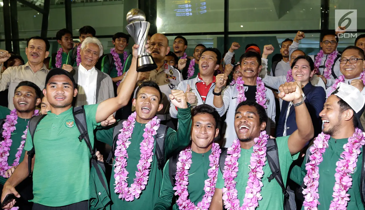 Para pemain Timnas Indonesia U-22 foto bersama dengan mengangkat Piala AFF U-22 2019 di Bandara Soekarno Hatta, Tangerang, Rabu (27/2). Timnas Indonesia  tiba di tanah air setelah menjuarai Piala AFF U-22 2019 di Kamboja. (Liputan6.com/Herman Zakharia)