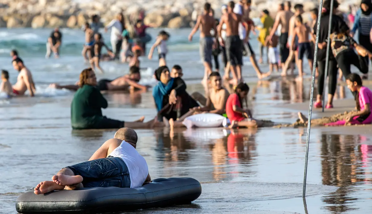 Seorang pria muslim bersantai di atas pelampung saat berwisata sambil menghabiskan libur lebaran pantai laut Mediterania di Tel Aviv, Israel, 26 Jni 2017. (AFP PHOTO / JACK GUEZ)