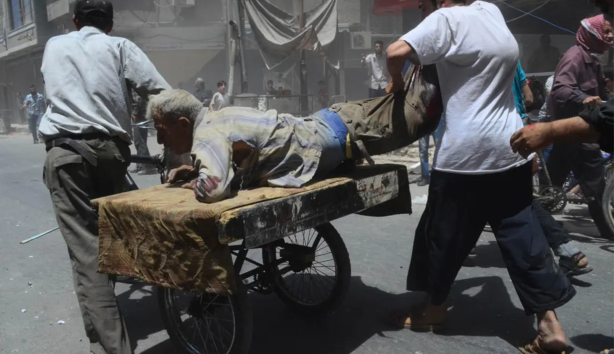 Ledakan bom mobil tersebut melukai orang yang sedang beraktivitas di   pusat kota Douma. Tampak seorang pria yang terluka dibawa dengan gerobak (REUTERS/Yousef Albostany)