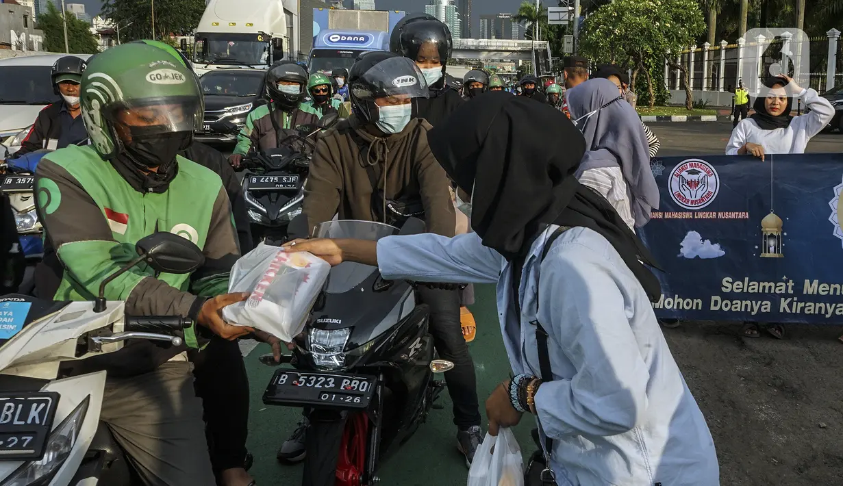 Aliansi Mahasiswa Lingkar Nusantara melakukan aksi dengan membagikan takjil di depan Gedung DPR/MPR, Jakarta, Rabu (6/4/2022). Dalam aksinya, mereka mendesak DPR untuk segera membentuk pansus terkait penambangan batu bara. (Liputan6.com/Johan Tallo)