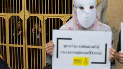 Penjaga menonton aktivis Amnesty International melakukan aksi tolak hukuman mati dengan suntik di depan penjara Bang Kwang di Nonthaburi, Bangkok (19/6). Mereka mengutuk hukuman mati terhadap Theerasak Longji pada 18 Juni 2018. (AFP PHOTO / Romeo Gacad)