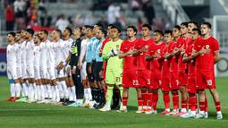 Para pemain starting XI Timnas Indonesia U-23 (kanan) berbaris menyanyikan lagu kebangsaan Indonesia Raya jelang dimulainya laga ketiga Grup A Piala Asia U-23 2024 menghadapi Yordania U-23 di Abdullah bin Khalifa Stadium, Doha, Qatar, Minggu (21/4/2024). (AFP/Karim Jaafar)