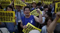 Dalam aksinya, para demonstran membawa beragam tulisan yang menentang rencana kebijakan PM Shinzo Abe yang ingin memperluas peran militer Jepang, (30/6/2014). (REUTERS/Issei Kato)