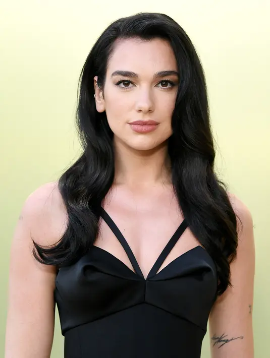 <p>Penampilan Dua Lipa, penyanyi sekaligus penulis lagu asal Inggris saat berpose setibanya untuk peragaan busana Versace Fall/Winter 2023 di Pacific Design Center, West Hollywood, California, Amerika Serikat, 9 Maret 2023. Dua Lipa memilih riasan sederhana untuk mempercantik penampilannya. (Jon Kopaloff/Getty Images/AFP)</p>
