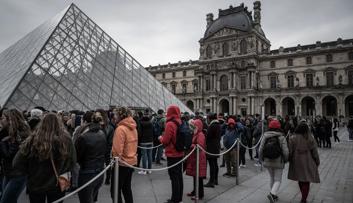 Pengunjung mengantre di luar Pyramid, pintu masuk utama menuju museum Louvre, di Paris, Rabu (4/3/2020). Louvre di Paris, museum yang paling banyak dikunjungi di dunia, kembali dibuka setelah pegawai yang khawatir dengan penularan virus corona setuju kembali masuk kerja. (Philippe LOPEZ/AFP)