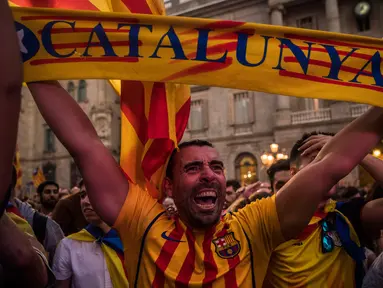 Seorang pria bersorak setelah Parlemen Catalonia mendeklarasikan kemerdekaan dari Spanyol di luar Gedung Palau Generalitat, Barcelona, Jumat (27/10). Sejumlah masyarakat pendukung kemerdekaan, turun ke jalan dan meneriakkan 'Liberty'. (AP/Santi Palacios)