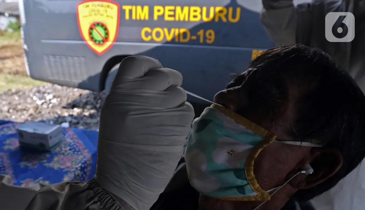 Petugas melakukan swab antigen terhadap pengendara yang melintas di Kedungwaringin, Kabupaten Bekasi, Kamis  (29/4/2021). Satlantas Polres Metro Bekasi melakukan swab antigen dan sosialisasi larangan mudik jelang lebaran di perbatasan Kabupaten Bekasi dan Karawang. (Liputan6.com/Herman Zakharia)