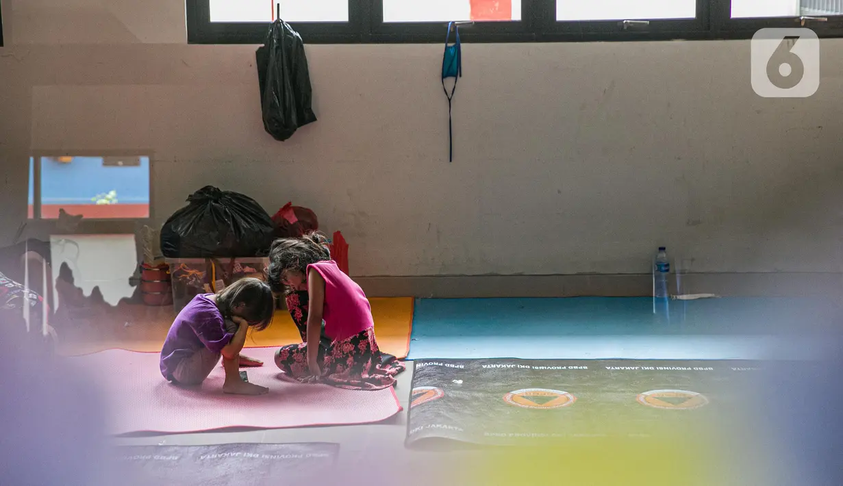 Dua orang anak korban banjir terlihat di salah ruang kelas di gedung SDN 01/02 Kampung Melayu, Jakarta, Selasa (9/2/2021). Gedung sekolah di Kebon Pala tersebut menjadi salah satu posko pengungsian bagi sebagian korban banjir Kampung Melayu. (Liputan6.com/Faizal Fanani)