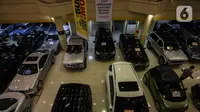 Pedagang melakukan perawatan pada mobil bekas yang dijualnya di bursa mobil bekas sebuah pusat perbelanjaan di Jakarta, Jumat (26/3/2021). Perusahaan pembiayaan dengan segmen kredit mobil bekas tak terlalu khawatir mengenai dampak kebijakan subsidi pajak mobil baru. (Liputan6.com/Johan Tallo)