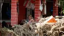 Seorang perempuan duduk di balkon rumah yang terendam banjir yang dipicu badai dan hujan deras di desa Bourtzi di pulau Evia, Yunani, Senin (10/8/2020). Tujuh orang, termasuk dua lansia dan bayi delapan bulan, tewas saat badai melanda pulau Evia pada Minggu kemarin. (AP Photo/Thanassis Stavrakis)