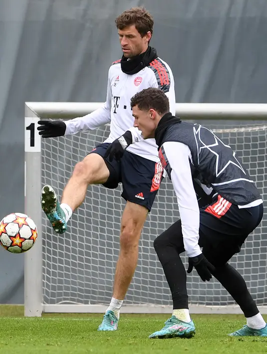 Penyerang Bayern Munchen, Thomas Mueller (kiri) dan bek Benjamin Pavard mengikuti sesi latihan di Munich, Jerman, Selasa (5/4/2022). Munchen akan bertanding melawan Villarreal pada leg pertama perempat final Liga Champions. (AFP/Christof Stache)