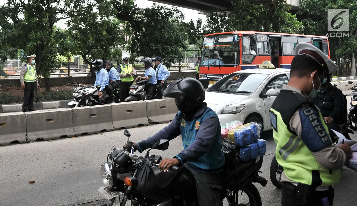 Polisi melakukan tilang terhadap pengendara yang melintasi jalur bus Transjakarta di Jalan Yos Sudarso, Jakarta, Senin (21/1). Razia rutin ini digelar untuk menjaring pengendara yang nekat menerobos jalur bus Transjakarta. (Merdeka.com/Iqbl Nugroho)