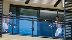 Petenis pria peringkat satu dunia, Novak Djokovic melakukan latihan di balkon hotel, Adelaide, Australia, Rabu (20/1/2021). (Foto: AFP/Morgan Sette)