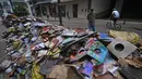 Ribuan buku rusak terlihat di jalan setelah hujan lebat membanjiri toko buku di Petropolis, Brasil, 19 Februari 2022. Sebanyak 136 jenazah telah diidentifikasi hingga kini, menurut pejabat pertahanan sipil, di kota wisata yang biasanya indah, sekitar 60 km utara Rio de Janeiro. (MAURO PIMENTEL/AFP)