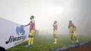 Oktovianus Maniani (kiri) dan dua rekannya dari pemain Persiba Balikpapan  hanya melihat kepulan asap flare saat melakukan pemanasan pada lagaTorabika SC 2016 di Stadion Gelora Bangkalan, Senin(13/6/2016).  (Bola.com/Nicklas Hanoatubun)