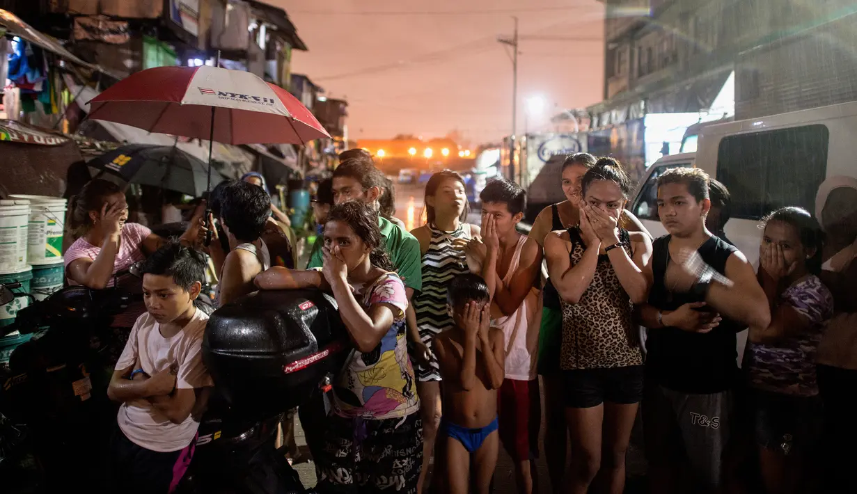 Dalam gambar yang diambil pada 28 September 2016, sejumlah warga bereaksi dekat TKP dimana tiga orang diduga pengedar narkoba tewas dibunuh penembak misterius di kawasan kumuh di Manila, Filipina. (AFP PHOTO/Noel CELIS)