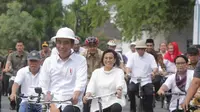 Presiden Joko Widodo (depan) didampingi sejumlah Menteri bersepeda menuju Kota Lama usai meninjau pembangunan Pasar Johar Semarang, Jawa Tengah, Senin (30/12/2019). Kunjungan ke Kota Lama untuk mempromosikan kawasan tersebut sebagai destinasi wisata. (Liputan6.com/Gholib)