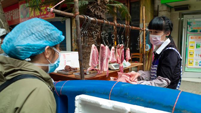 Seorang wanita membeli daging di Wuhan, ibu kota Provinsi Hubei, China tengah, (16/4/2020). Seiring meredanya epidemi COVID-19, kehidupan berangsur kembali normal di Wuhan. (Xinhua/Shen Bohan)