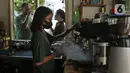 Pekerja menyiapkan kopi untuk pengunjung yang berjemur di halaman kedai kopi Nyambi Ngopi, Depok, Jawa Barat, Selasa (3/8/2021). Kedai kopi ini menjadikan halamannya untuk program Ngopi Sambil Berjemur pada pukul 09.00-10.00 WIB dengan menerapkan protokol kesehatan. (Liputan6.com/Herman Zakharia)
